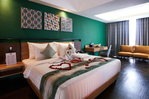 a bedroom with a large bed with a green wall at Kyriad Hotel Muraya Aceh in Banda Aceh