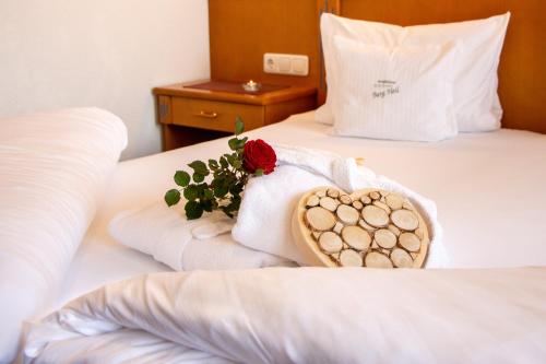 a hotel room with a towel and a rose on a bed at Wohlfühlhotel Berg Heil in Holzgau