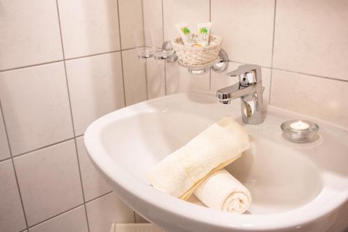 a bathroom with a sink with a towel at Wohlfühlhotel Berg Heil in Holzgau
