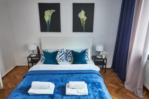 ワルシャワにあるNoctis Apartment Plac Grzybowskiのベッドルーム1室(青いベッド1台、枕2つ付)
