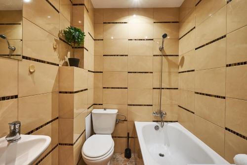 a bathroom with a toilet and a tub and a sink at Noctis Apartment Plac Grzybowski in Warsaw