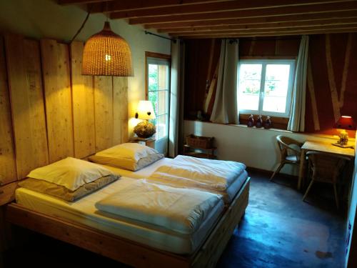 1 dormitorio con 2 camas, mesa y ventana en Arrest-en-Baie, en Arrest