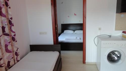 a small room with a bed and a washing machine at Manos Apartments in Agios Nikolaos