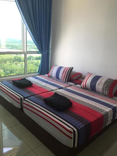 a bed sitting in a room with a window at DeCentrum Residences in Kajang