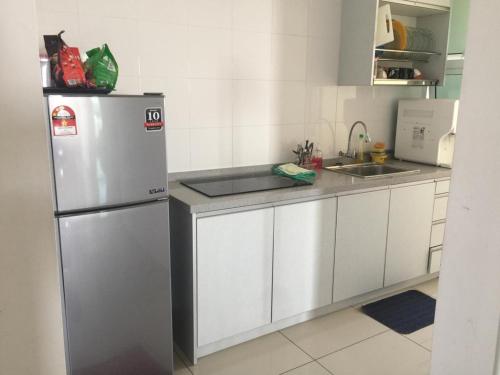 een keuken met een koelkast en een wastafel bij DeCentrum Residences in Kajang