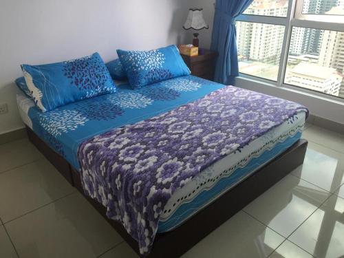 een slaapkamer met een bed met blauwe lakens en een raam bij DeCentrum Residences in Kajang