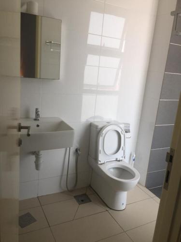 a bathroom with a toilet and a sink at DeCentrum Residences in Kajang