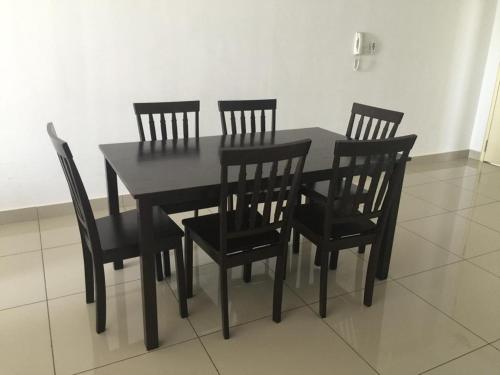 a black dining room table and four chairs at DeCentrum Residences in Kajang
