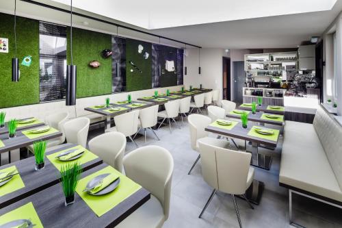 a restaurant with long tables and white chairs at Star Apart Hotel Sachsenhausen in Frankfurt