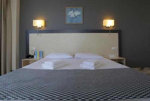 a bedroom with a large bed with two towels on it at Aurora Hotel Klaipeda in Klaipėda