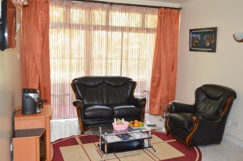 two leather chairs and a table in a living room at Golf Hotel Kakamega in Kakamega