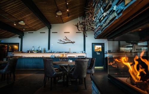 a restaurant with a fireplace and a table and chairs at Eriks Villa in Funäsdalen