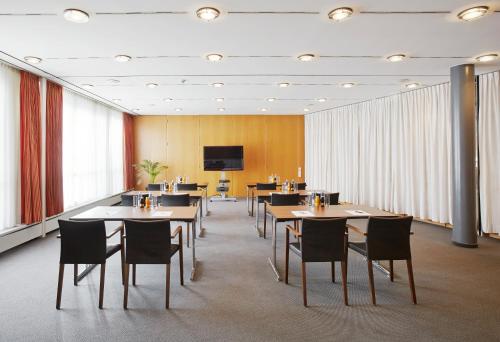 a conference room with tables and chairs and a tv at Hotel Krone in Dornbirn