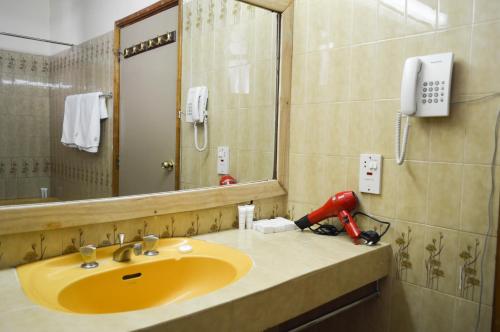 Kakamega的住宿－Golf Hotel Kakamega，浴室设有黄色水槽和镜子