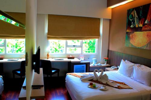 Kyriad Arra Hotel Cepu في Cepu: غرفة في الفندق مع سرير عليه صينية طعام
