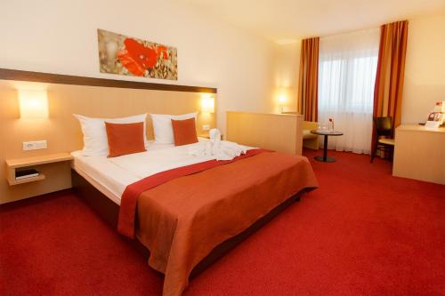 una camera con un grande letto in una camera d'albergo di Montana-Hotel Ellwangen a Ellwangen