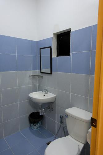 a bathroom with a toilet and a sink at Bangles Homestay in Coron