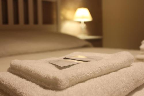 a pile of towels sitting on top of a bed at B&B Villa dei Cigni Reali in Carpi