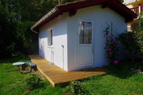 a small shed with a door on a deck at Chambres d'hôtes "HOR DAGO" près de la gare d'Hendaye avec le petit-déjeuner in Hendaye
