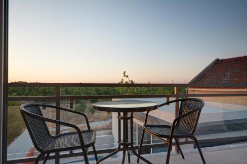 a table and chairs on a balcony with a view at Paradise Terrace House in Quinta do Conde