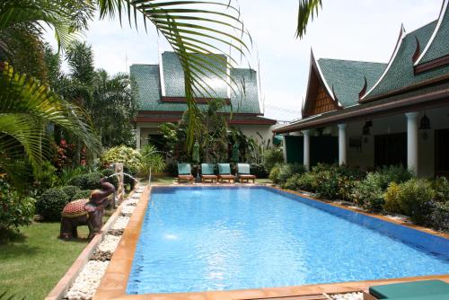 a swimming pool in the yard of a house at Villa Angelica Bed and Breakfast in Phuket in Bang Tao Beach