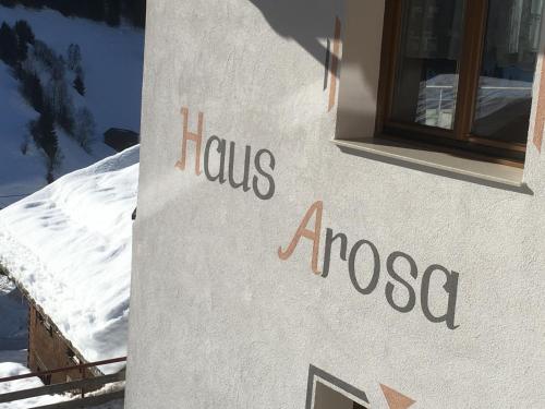 a sign on the side of a building with a window at Haus Arosa in Kappl
