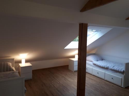 a attic bedroom with a bed and a window at Ferienwohnung Emely in Mechernich