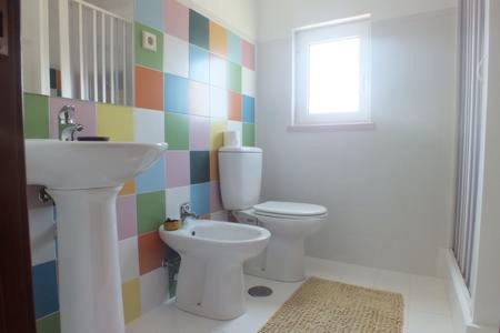 a bathroom with a sink and a toilet and a window at Casa da Avó Tita in Cardeal