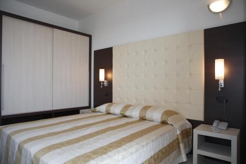 a bedroom with a large bed and a telephone at Eraclea Palace Appartements in Eraclea Mare