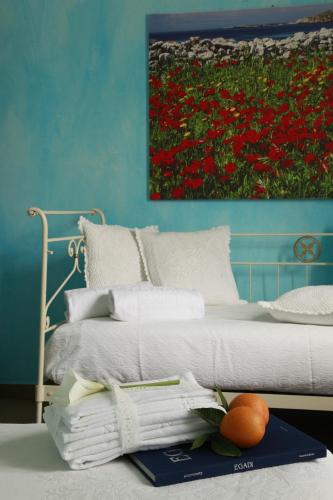 a bedroom with a bed with a painting on the wall at Albergo Egadi in Favignana