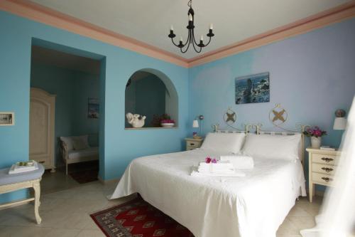 a bedroom with blue walls and a white bed at Albergo Egadi in Favignana