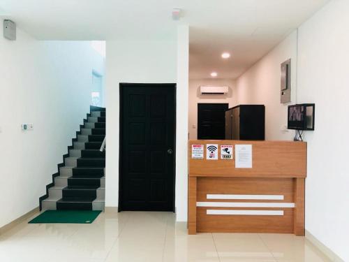 a hallway with a black door and a staircase at LunaStay (Shared Common Area) in Lunas