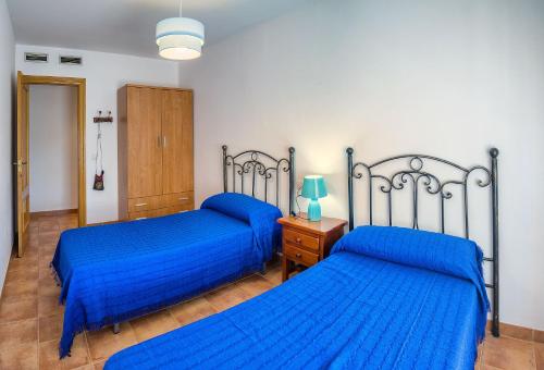 ロケタス・デ・マルにあるApartamento 2 dormitorios en la mejor zona de Roquetasの青いシーツが備わる客室のベッド2台
