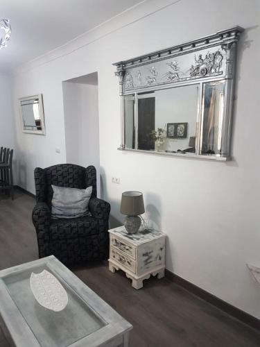 a living room with a chair and a mirror at Casa Algill in Torrox