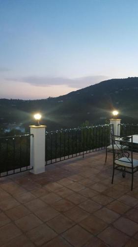 a patio with a table and chairs and lights at Casa Algill in Torrox