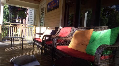 a porch with wicker chairs with colorful pillows on them at Ottawa Backpackers Inn in Ottawa