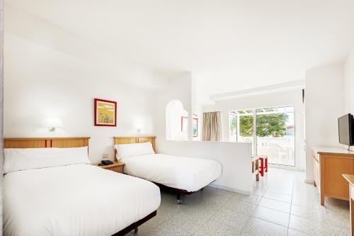 a hotel room with two beds and a tv at Apartamentos LIVVO Koala Garden in Maspalomas