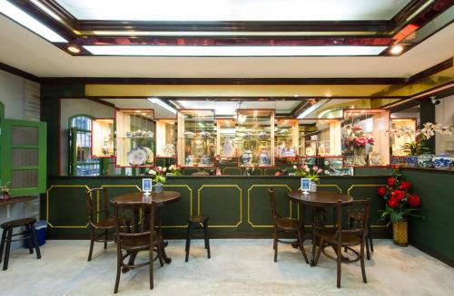 a restaurant with tables and chairs in a room at The Neighbors Hostel in Phuket Town