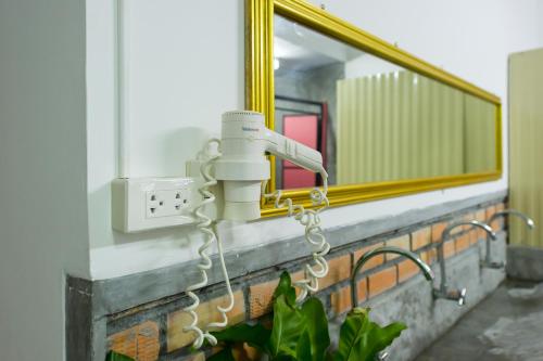 a bathroom with a mirror and a hair dryer at The Neighbors Hostel in Phuket Town