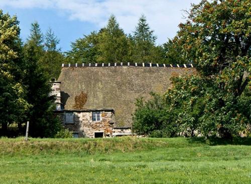 an old stone house in a field with trees at Loire-Gerbier-Mézenc in Sainte-Eulalie