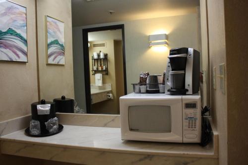 a microwave sitting on a counter in a hotel room at Ramada by Wyndham Viscount Suites Tucson East in Tucson