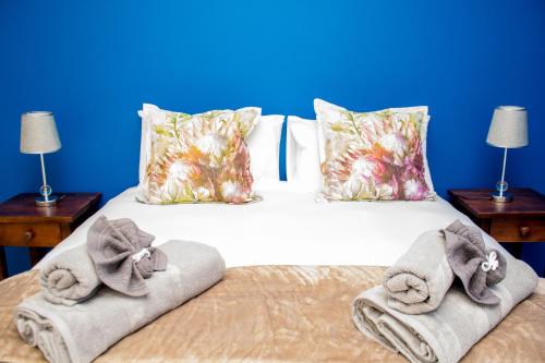 een slaapkamer met een bed met handdoeken erop bij Camello in George