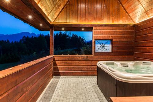 a bath tub in a wooden room with a view at Quality House - Cisza nad Doliną in Zakopane