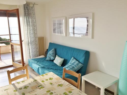 a living room with a blue couch and a table at Villa Matilde in Grado