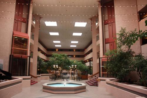 a lobby with a fountain in the middle of a building at Ramada by Wyndham Viscount Suites Tucson East in Tucson