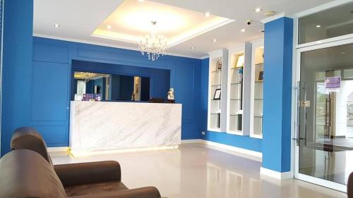 a lobby with a white counter in a blue wall at Garden Hill Hotel in Trang