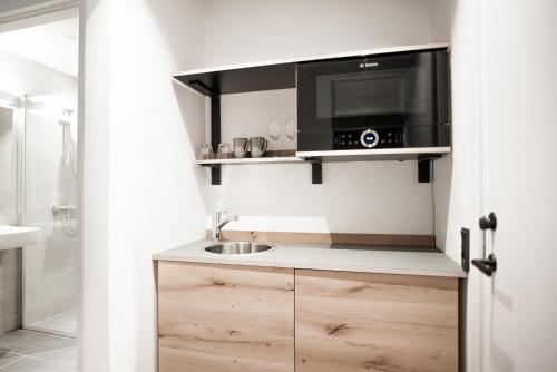 a small kitchen with a sink and a microwave at Hotel Town Living in Ringkøbing