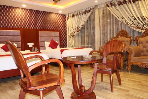 a hotel room with a bed and a table and chairs at Hyders Park The Business Hotel in Thanjāvūr