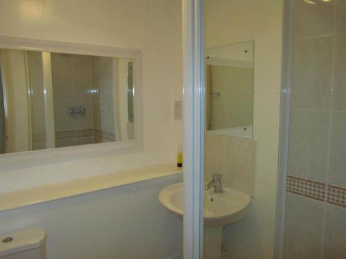a bathroom with a sink and a toilet and a mirror at River Walk Inverness in Inverness