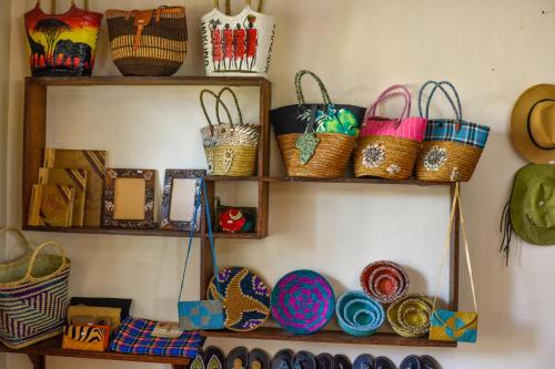 a shelf filled with baskets and hats on a wall at Kena Beach Hotel in Matemwe